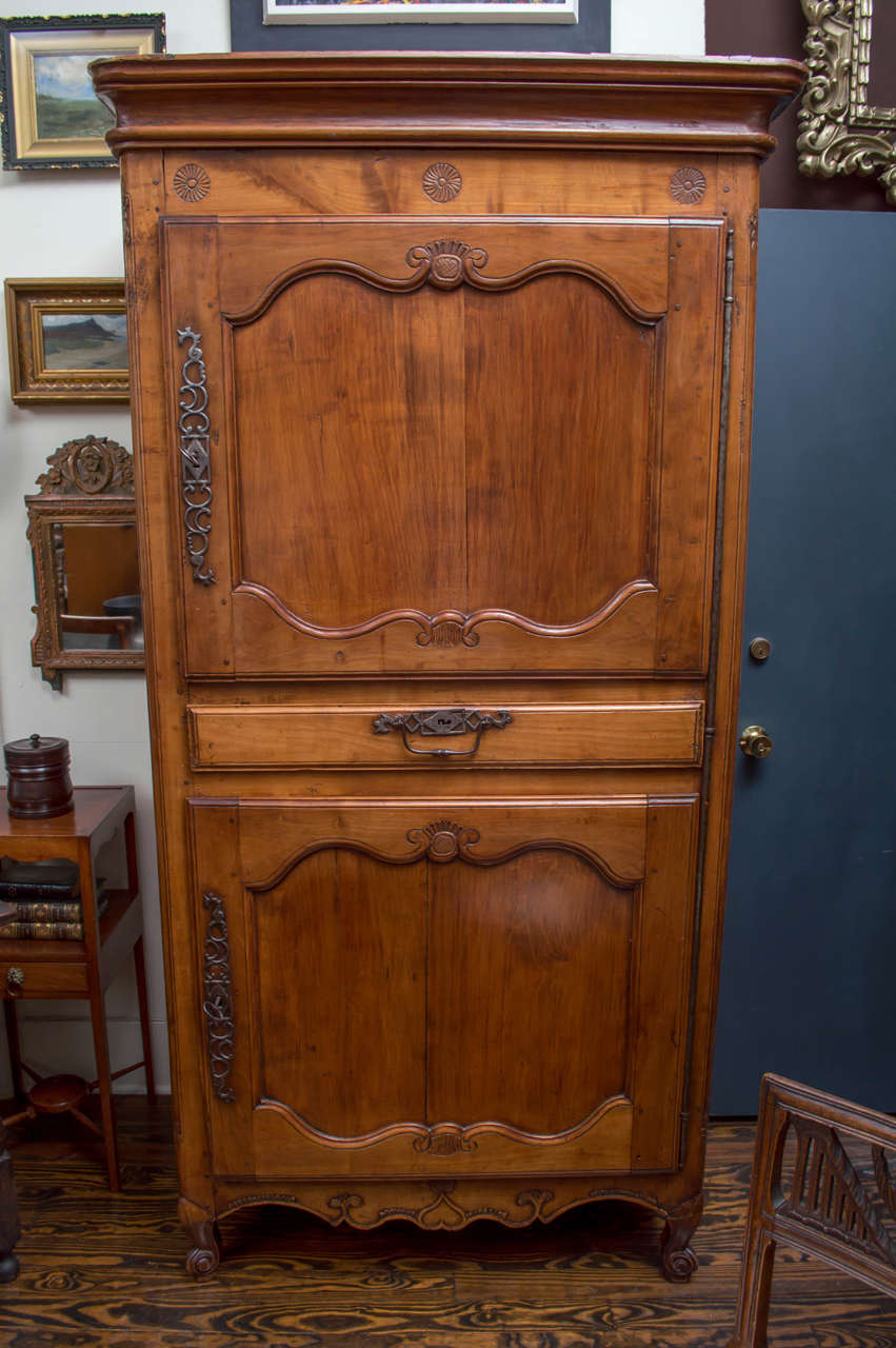18th century French bonnetiere, figured cherry. Two cabinets with a drawer in the middle. Good carved details overall. Original pierced steel hardware and hinges, circa 1790.