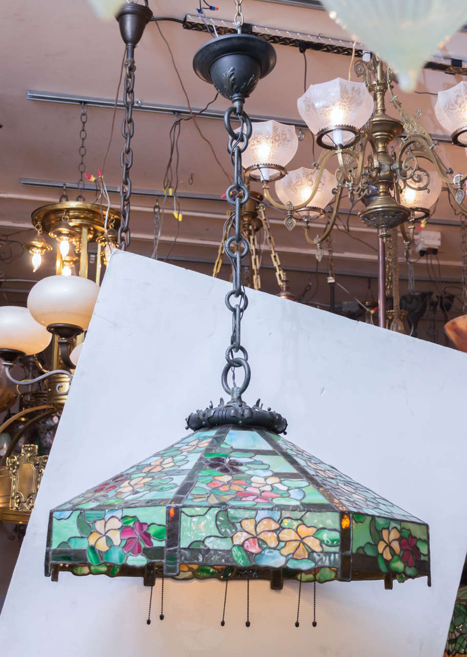 This large, colorful and impressive leaded glass hanging chandelier we believe was done by the noted maker 