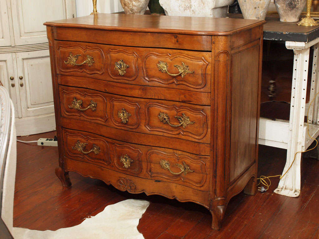 Stunning hand carved, french walnut commode with serpentine front.  Original aged bronze hardware and locking key.  Beautiful wood patina.