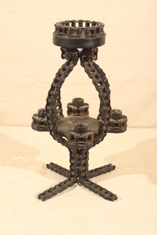 A very well-designed piece of Folk Art made from Industrial roller chain, this piece has four cups for tapers and an upper deck for a pillar candle at the top. Each link joint has been carefully spot-welded to stay in place; the original black paint