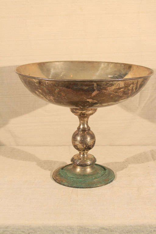 This oversize stylized chalice or silverplate centerpiece sports smooth and sculptural lines and exaggerated proportions overall; an enormous beaded-rim bowl sits atop a beautifully turned stem and stands on a weighted base for the perfect tabletop