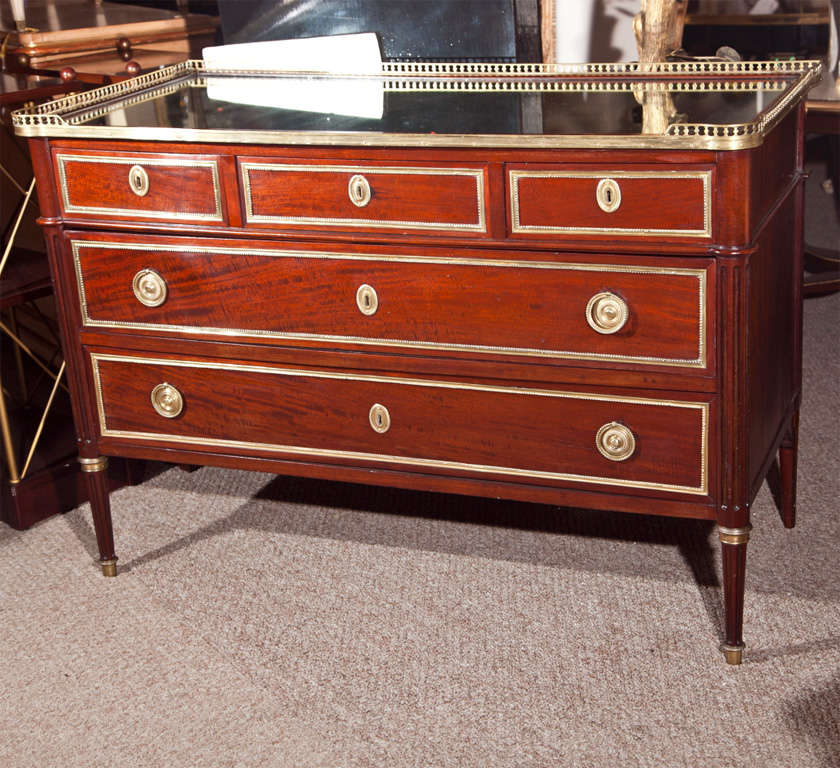 Fine French mahogany commode in the style of French Louis XVI, turn of the century, the glass top with three or four bronze gallery over a conforming case fitted with three over two drawers, bronze banded, oak secondary with dovetail, raised on