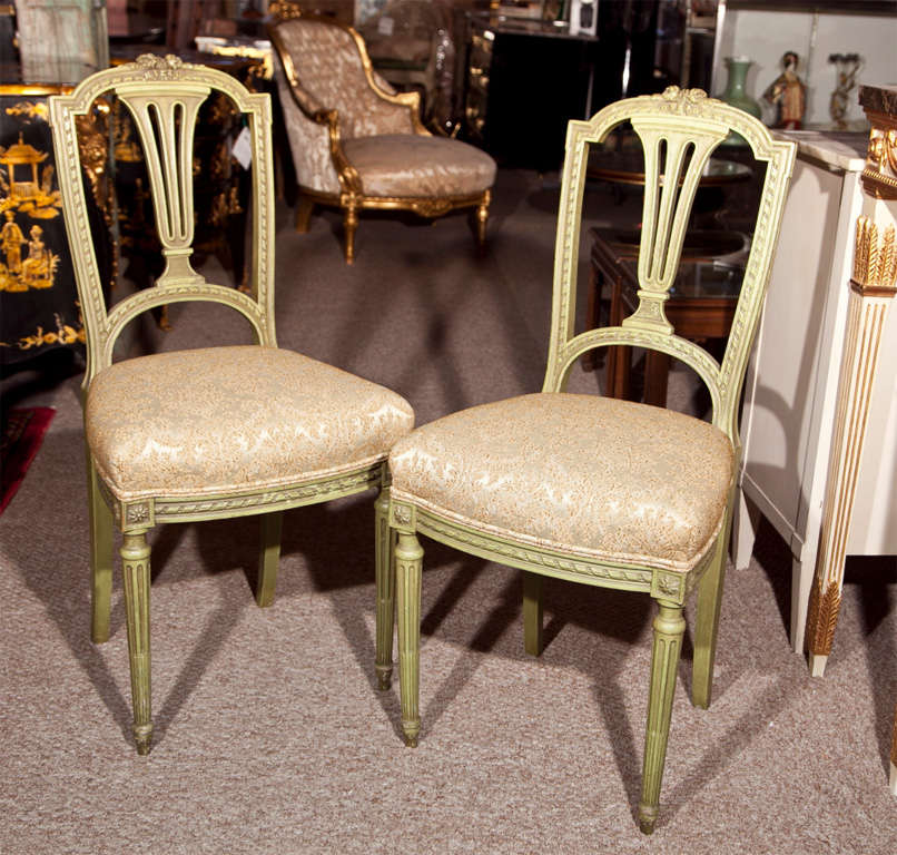 Pair of French green distress painted side chairs, 20th century, in the style of Louis XVI, padded seat, raised on fluted tapering legs.