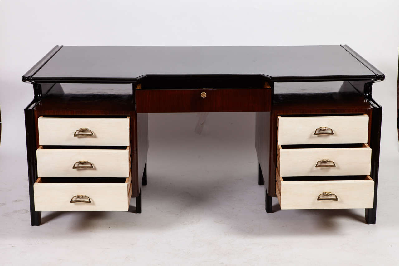 Executive desk attributed Arch. Carlo de Carli, 1950
Seven drawers ivory lacquered, rosewood and crystal black top
rosewood, brass, black crystal.

Measures: H 80cm, 99 x 180 cm.