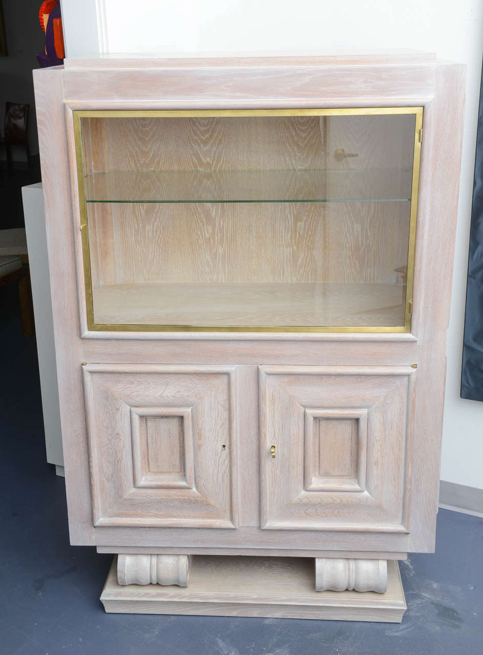 Cerused oak vitrine, the uper part  a display cabinet and the piece below is a set of drawers and shelves. Two round bases support the body.  In the style of Moreux

Circa 1940.