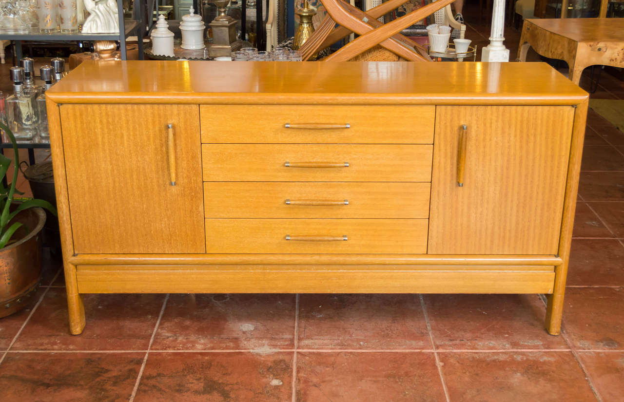 A Mid-Century mahogany sideboard or credenza by John Keal for Brown-Saltman.

Finish displays a very nice warm tone throughout. A pair of striking ribbon-grained cabinet doors each open to reveal an adjustable shelf. Has four drawers, the top one of
