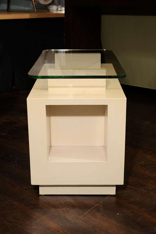 White-lacquered wood. Very architectural form with glass top and recessed front compartment. 
Although this design dates back to the 1940s, this particular table was executed circa 1966 for a private residence in Beverly Hills, CA.