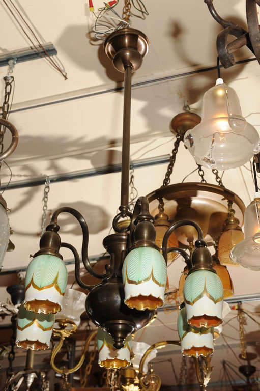 Simple and elegant, this six-arm chandelier has a rich brown patina and six of the best examples of American handblown glass of the period. These shades are referred to as pulled feather and are hard to find in large sets. The shades are period, and