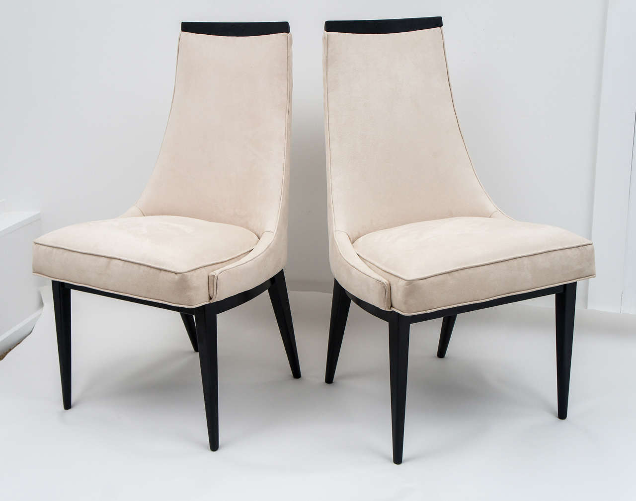 Hard to find set of dining chairs by Harvey Probber , including six side chairs and two armchairs. The wood at the top and legs have been ebonized, and the chairs have been re-upholstered in a neutral ultra-suede. We will be happy to provide