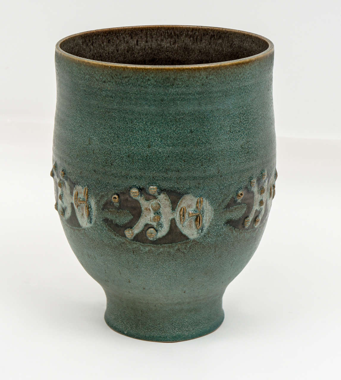 Dramatic piece by Edwin and Mary Scheier, important studio potters of the 20th C.This highly stylized creation is in a soft. muted green adorned with raised figures around the central portion.
This piece is signed and special!
