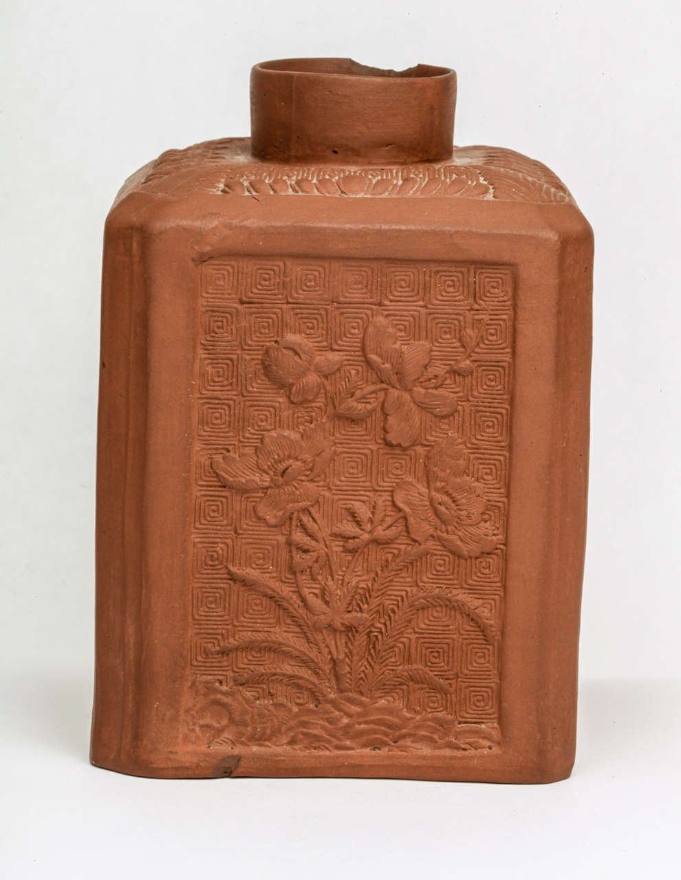 A rare English redware pottery rectangular tea caddy, each panel with a scrolled background and Oriental flowers