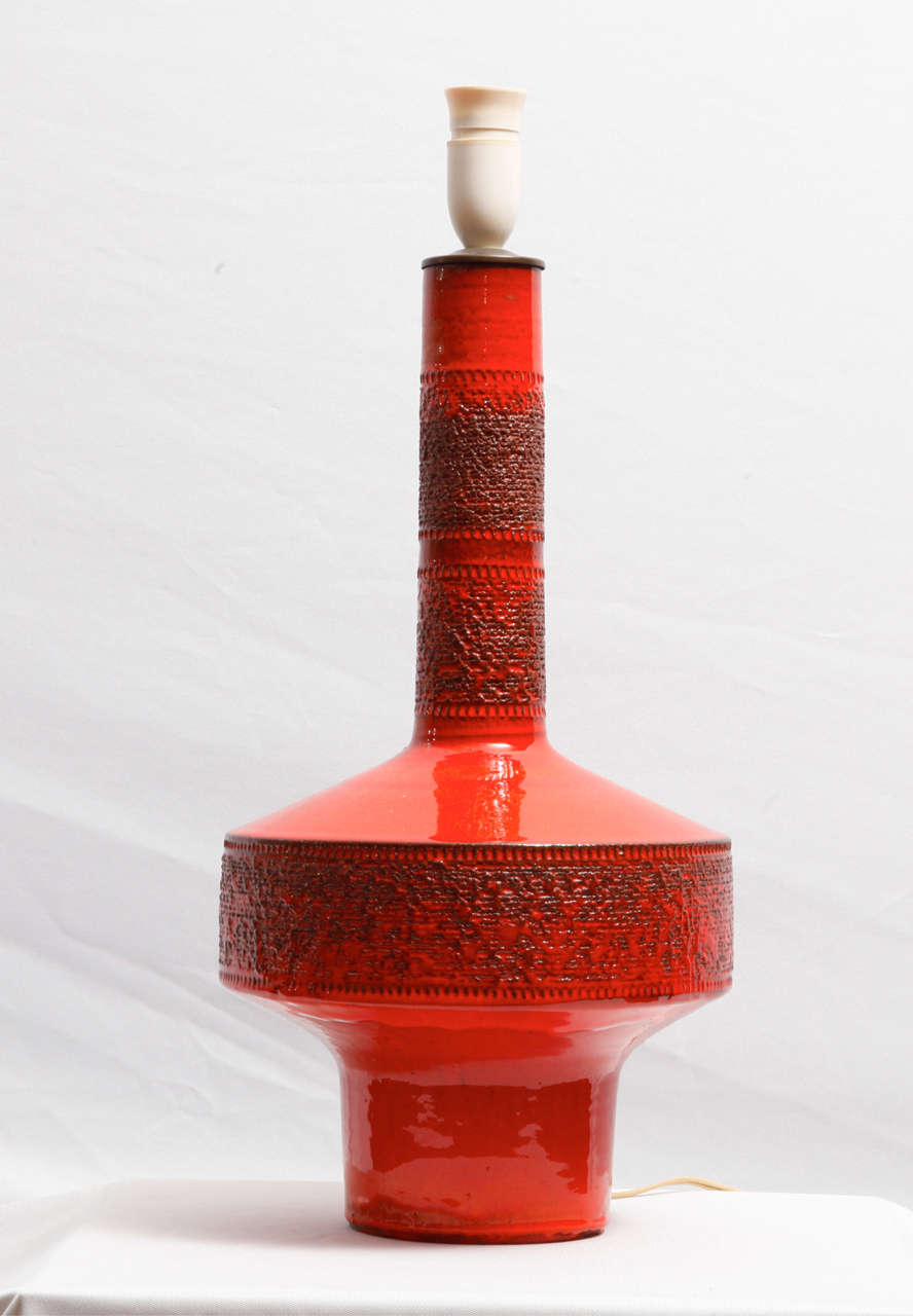 Tall red glazed ceramic table lamp designed by Rogier Vandeweghe (1923) and executed by Amphora, a Belgian ceramic workshop located in Brugges (B). Engraved surface decor.