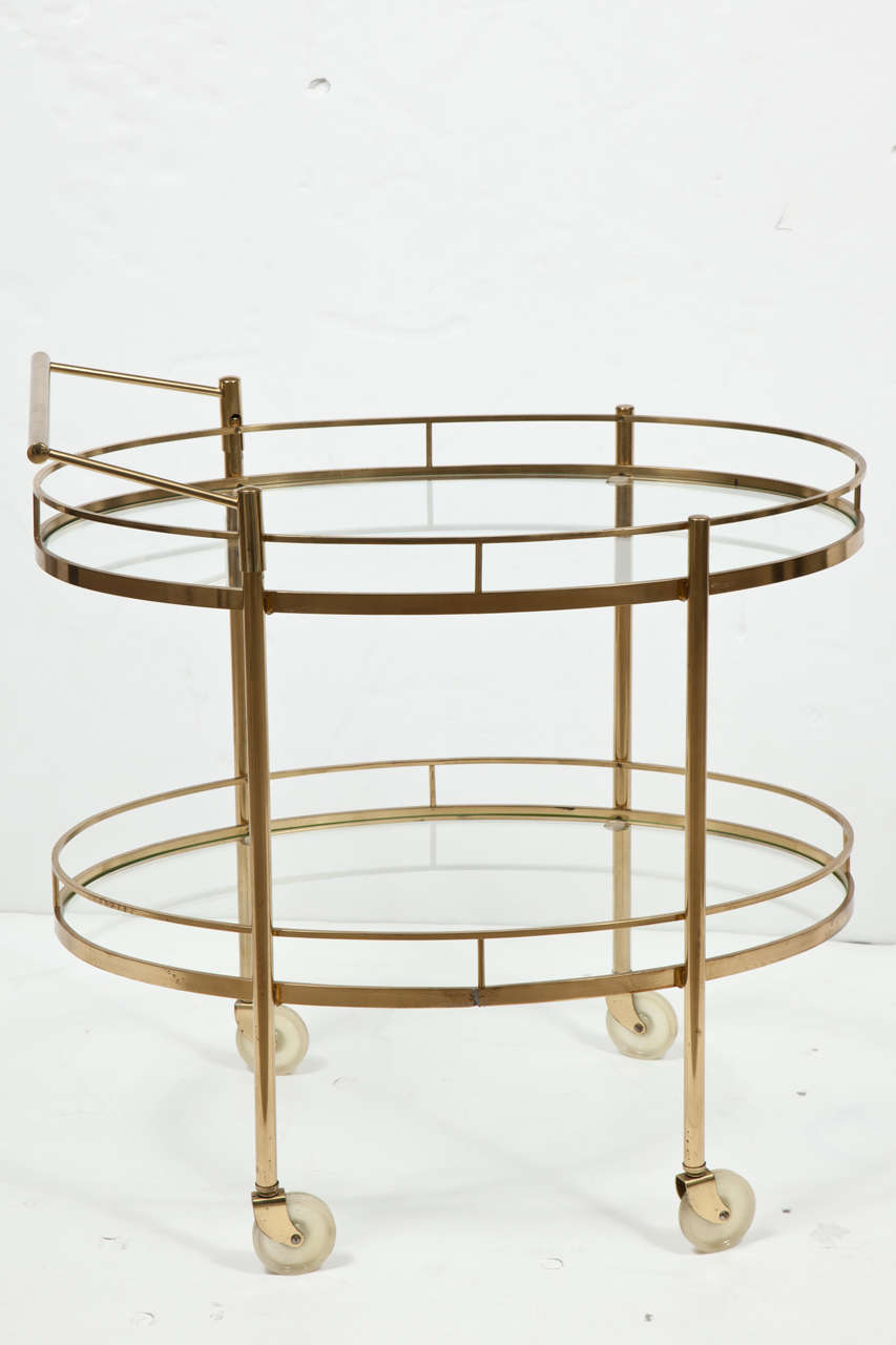 Elegant and Classic, professionally hand polished brass, two-tiered bar or tea cart with glass shelves and removable handle (handle can be placed on either end of the cart). Working wheels. Absolutely perfect condition.
