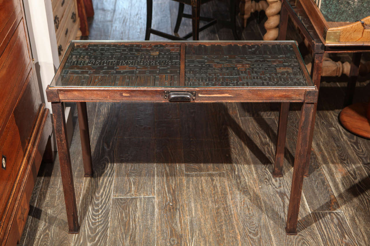 19th century antique drawer set in a contemporary iron base with glass top from France. 