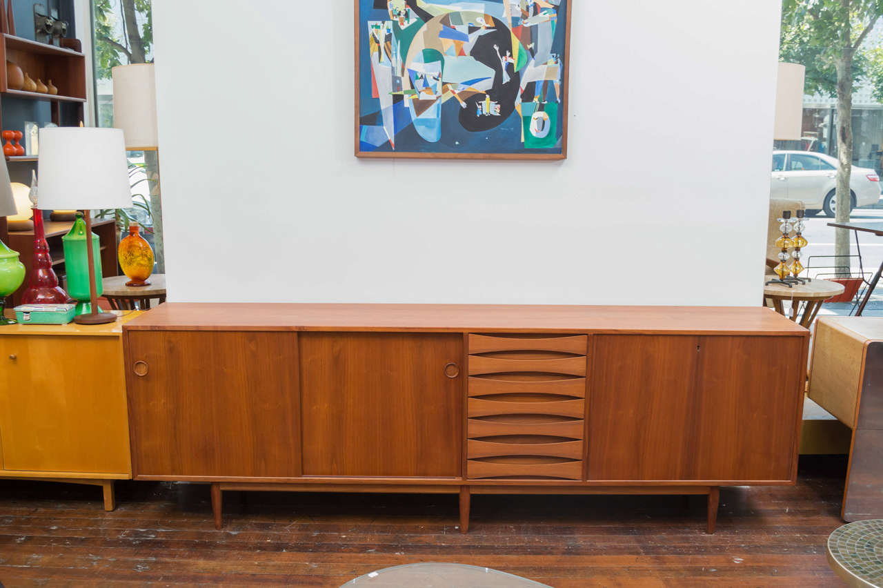 Large teak credenza designed by Arne Vodder in teak for Sibast Furniture Company drawers, shelves and a locking drop-down bar cabinet.
Perfectly refinished and labeled.