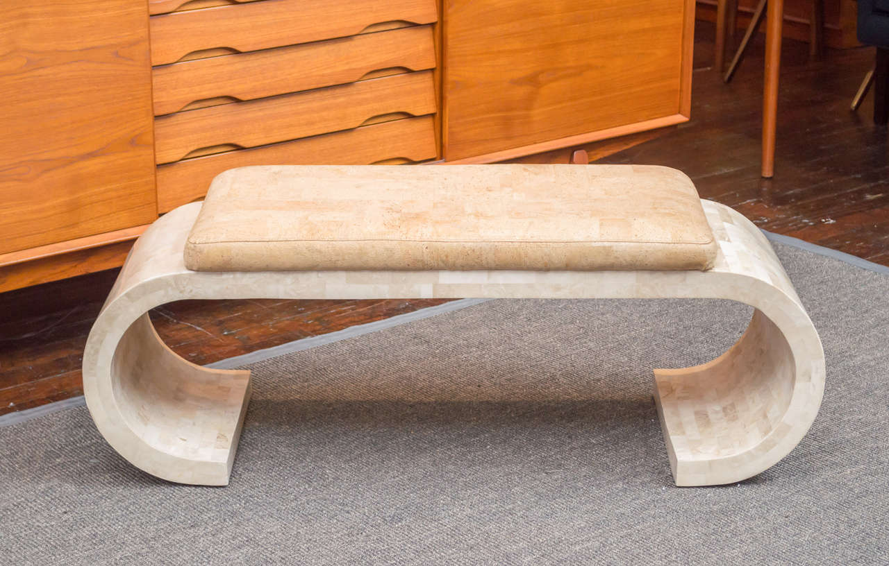 Kind of great 1980s travertine scroll form bench with faux cork upholstery. Very good original condition.