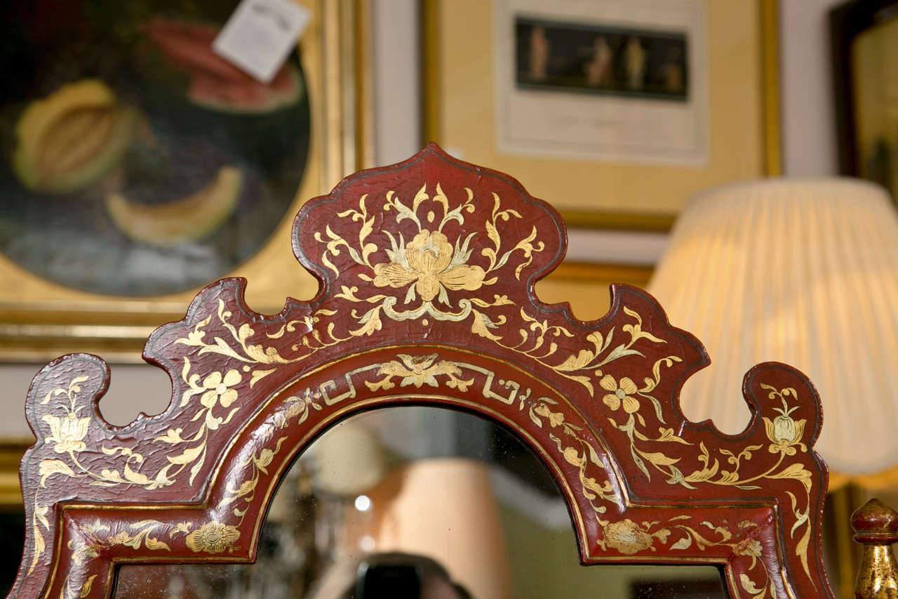 A spectacular English Georgian style red painted and parcel-gilt desk, overall depicting chinoiserie taste, dated from the late 19th century, the mirror on top of a drop-front secretary opening to cubby holes, over a set of two narrow drawers,