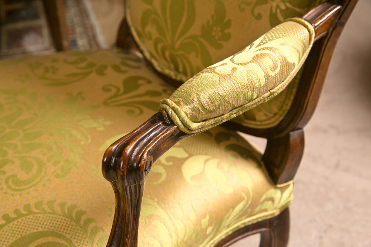 Pair of French Louis XV style walnut chairs, circa 1940s, domed back with downswept arms, padded back and armrests, raised on cabriole legs. A fine silk and Linen yellow and green design fabric in fine conditon.