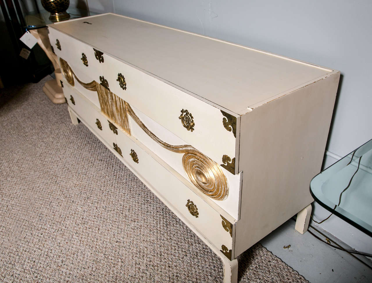 Mid-Century Modern sideboard, overall painted white and parcel-gilt, adorned with brass accents, raised on bracket feet.