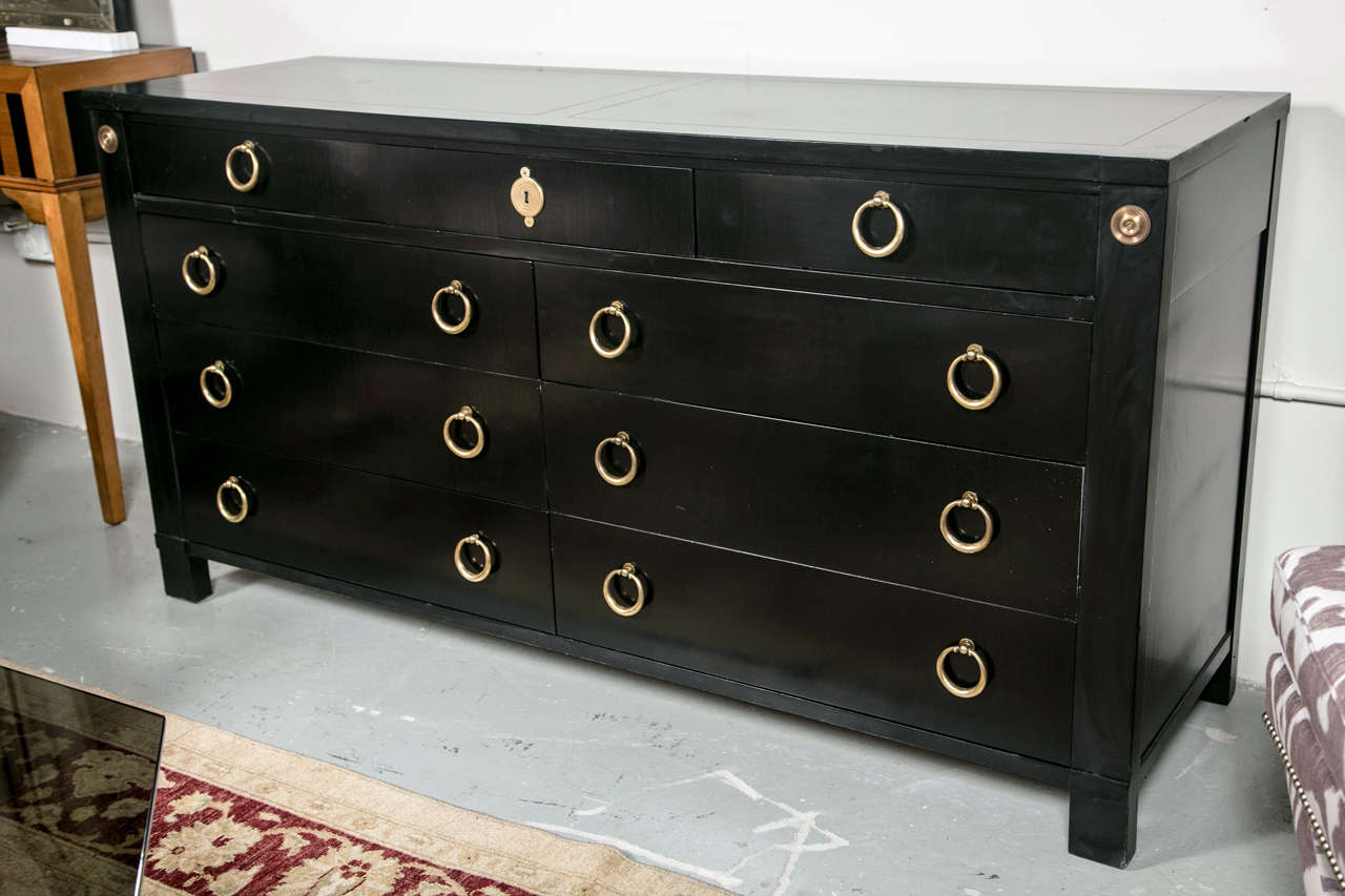 French dresser in the Empire taste, circa 1950s, overall ebonized, the frieze fitted with three small drawers, atop a set of 6 long drawers all decorated with brass loop pulls, raised on block feet. Stamped Baker. In the Manner of Maison Jansen