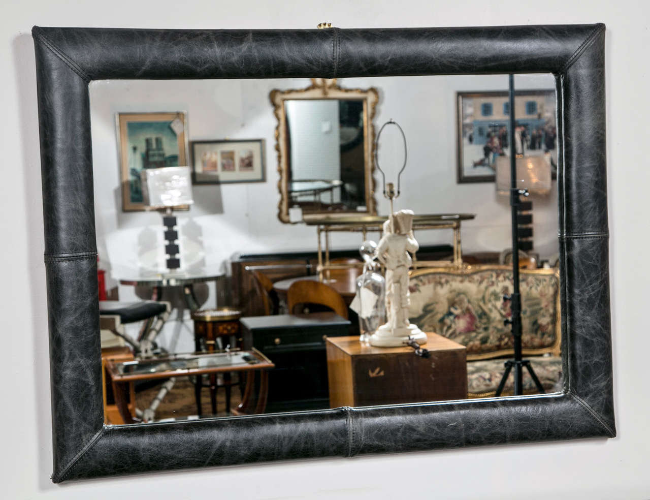 The rectangular glass surmounted on a dark charcoal color distress leather upholstered frame.