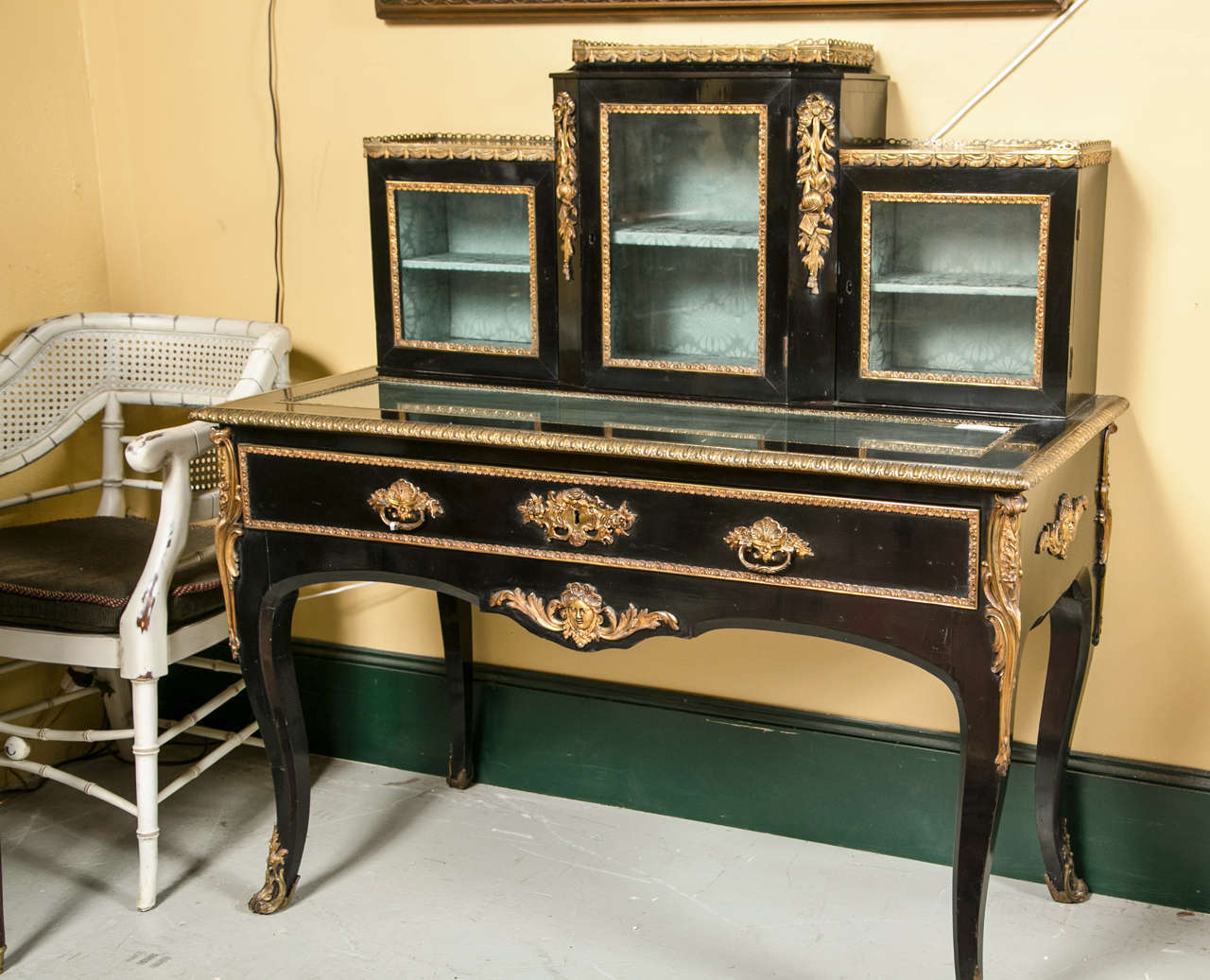 Lovely 19th / early 20th Century Showcase Desk Vitrine. Overall ebonized and adorned with gilt-bronze mounts, the galleried top of a three part shelving unit, on top of a glass top showcase table with a single drawer, raised on cabriole legs ending