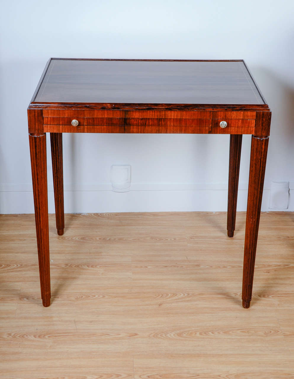 Elegant writing table in rosewood veneer, the tray is decorated with a light wood filet, two buttons allow to slide the tray. The table rests on four fluted legs,

France, 1940s.

René Joubert (1878-1931.)
Philippe Petit (1885-1945.)
D.I.M.