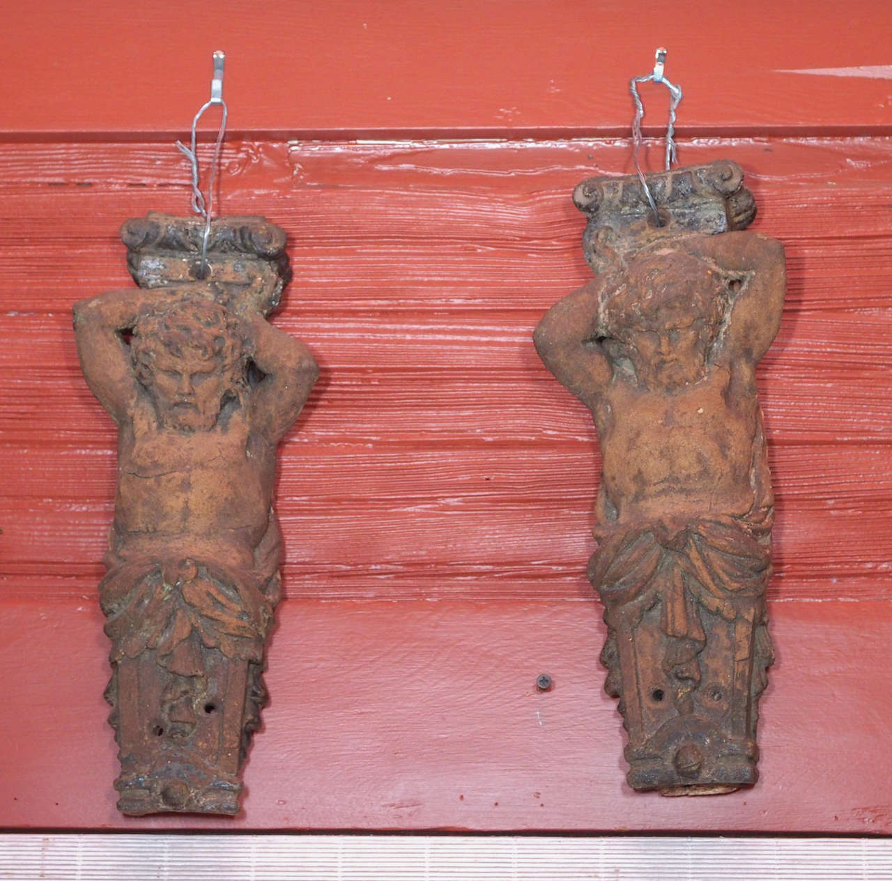 A pair of fabulous 18th century French figural terra cotta brackets or corbels.
Two atlantes holding a bracket above their heads with a draped sash around
their middle.