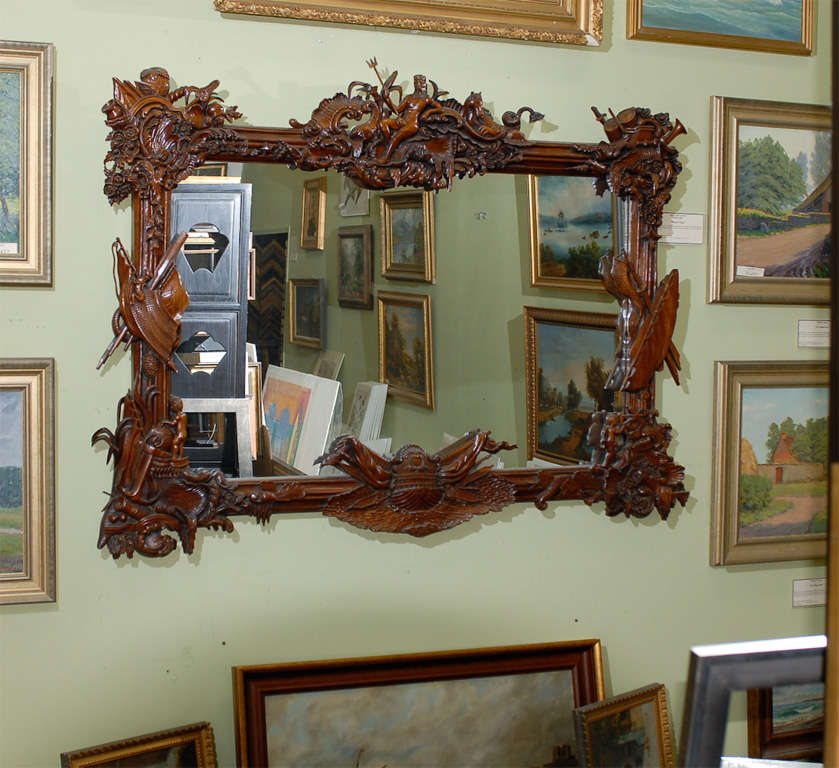 An American hand carved mirror of mahogany wood having eight very fine carvings all with nautical themes. The top center carving is Neptune reclining on waves with trident in hand flanked on the left by a large sea fish and on the right with a horse