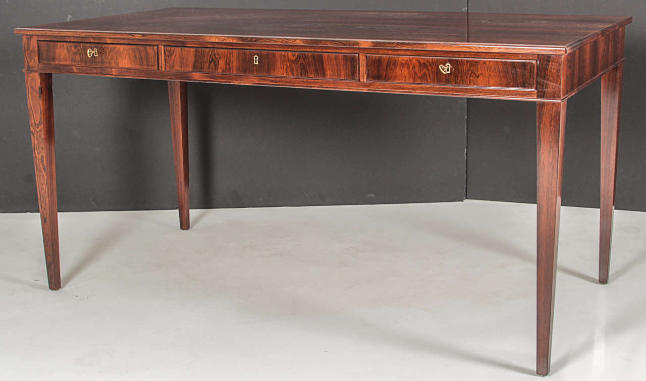 A Danish rosewood bureau-plat by Frits Henningsen,  Furniture designer and Cabinet Maker  (1889-1965). This desk is a classic example of Henningsen's elegant clean lines and use of quality woods with perfect balanced craftsmanship.

A rectangular
