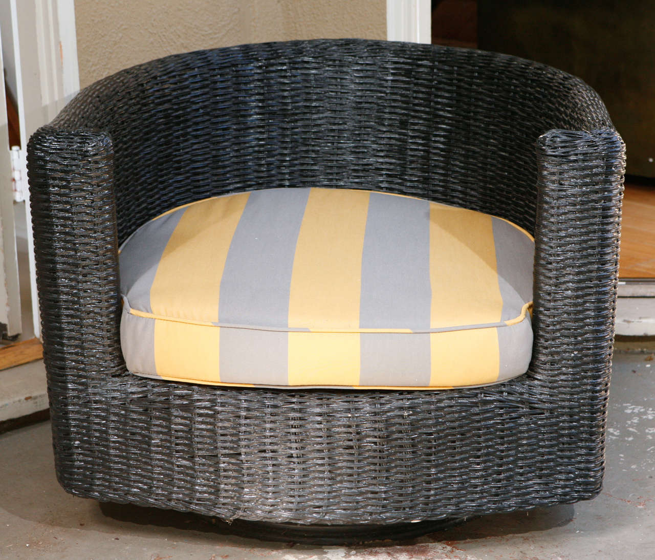 Featuring vintage grey and maize wide-striped upholstery, these bold and beautiful black rattan swivel chairs are one-of-a-kind beauties, perfect for a covered outdoor patio or even poolside.