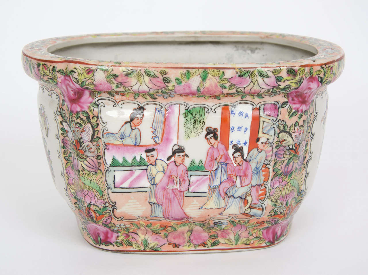 Chinese porcelain cache pots are generally rare items.

This pot has a lovely oval shape. It is decorated in the Canton, rose medallion manner with four alternating panels of groups of birds, butterflies and flowers and groups of people in a house