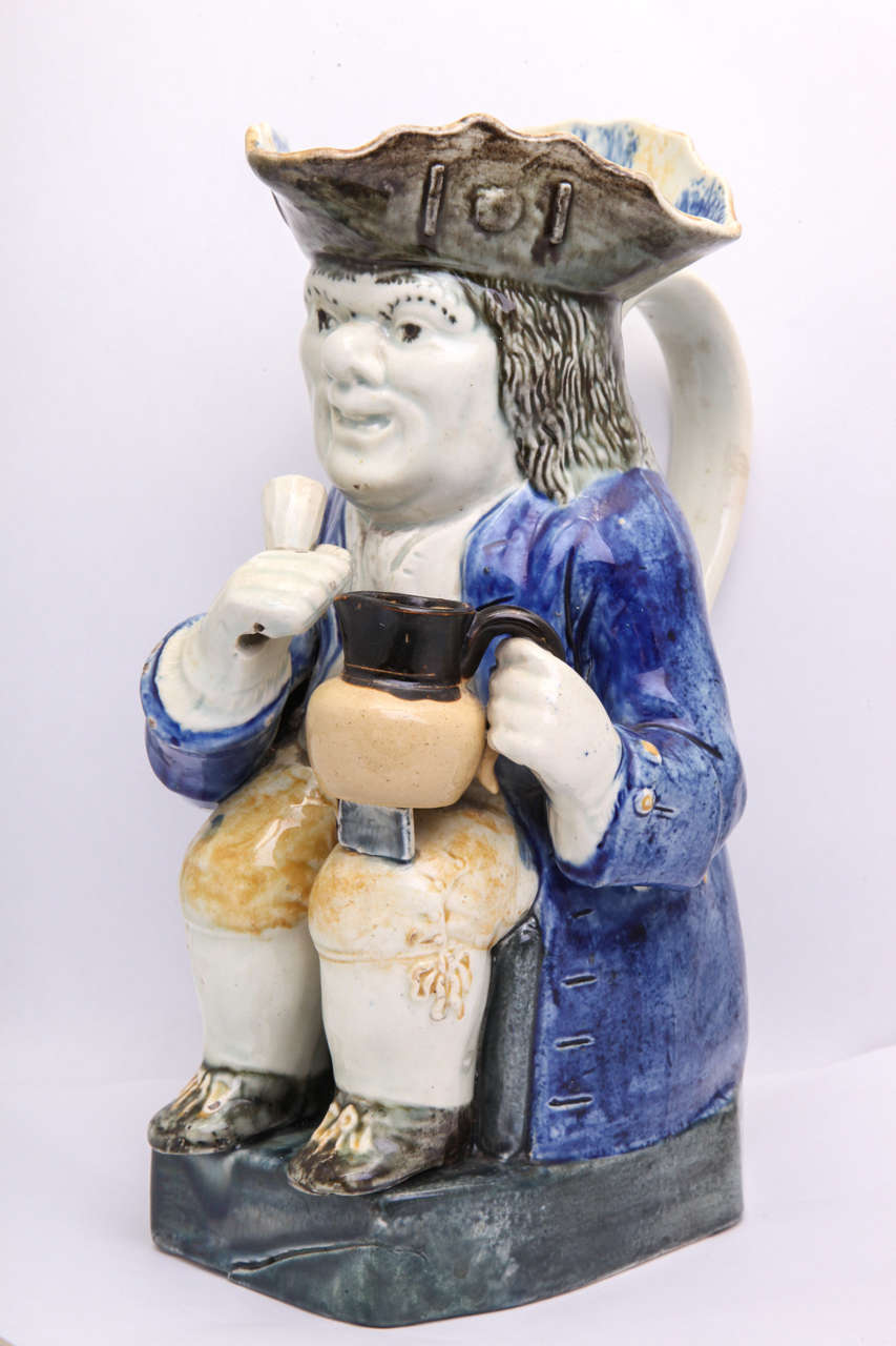 A rare English pearlware pottery toby jug with lobed hat decorated in underglaze Pratt colors, impressed crown mark