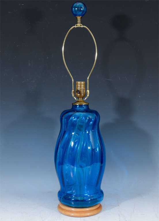 A pair of vibrant blue glass lamps by Blenko with matching blue globe finials. Each sits on a turned wood base.

Reduced from: $3,750