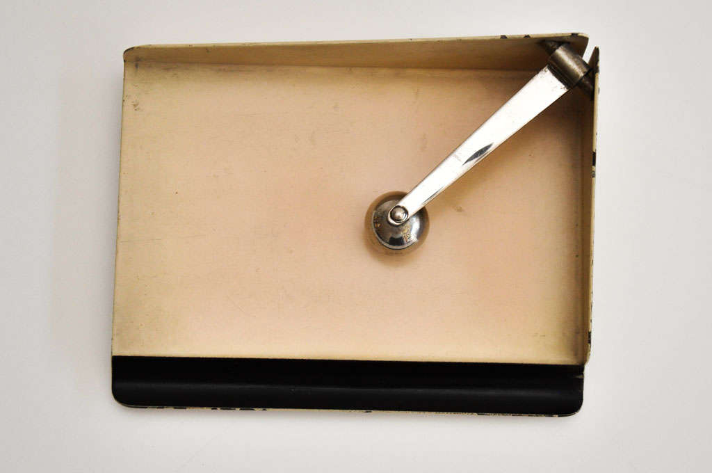Footed metal note paper holder by Marianne Brandt (1893-1983) for Rupplewerk. A rare and innovative modernist design by a Bauhaus master.  The weighted metal ball holds down the paper; the recessed area in front is for the pen.