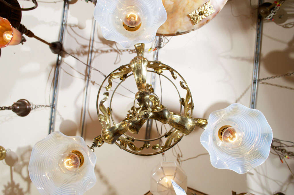 This sinewy and organic chandelier is a fine example of art nouveau lighting.  It is highlighted by three original opalescent swirl floraform glass shades.  A very organic and pleasing package.