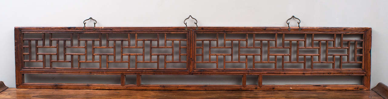 Chinese panel elegantly constructed with geometric fretwork. Includes three brass decorative fittings for wall hanging.