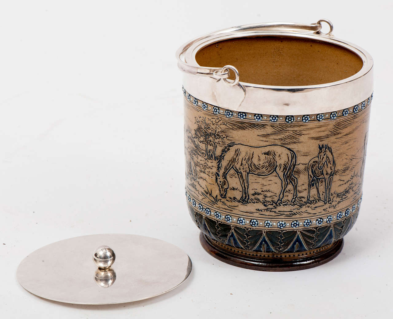 This fine saltglazed stoneware biscuit barrel from circa 1890 has Hannah Barlow's characteristic sgraffiti decoration of animals (in this case horses, donkeys and cows, both seated and standing) in a naturalistic landscape on a buff ground. The rim,