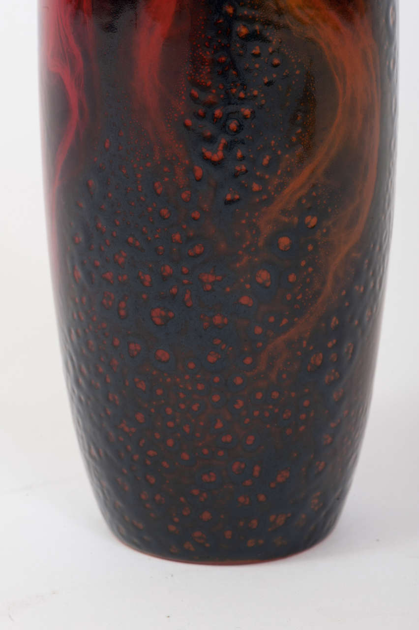 This striking pottery vase by Royal Doulton is from the Veined Flambe range manufactured from circa 1930 until the mid 1950's. Overlaid on a flambe red ground is a darker glaze which gives the impression of orange flames rising from the high fired