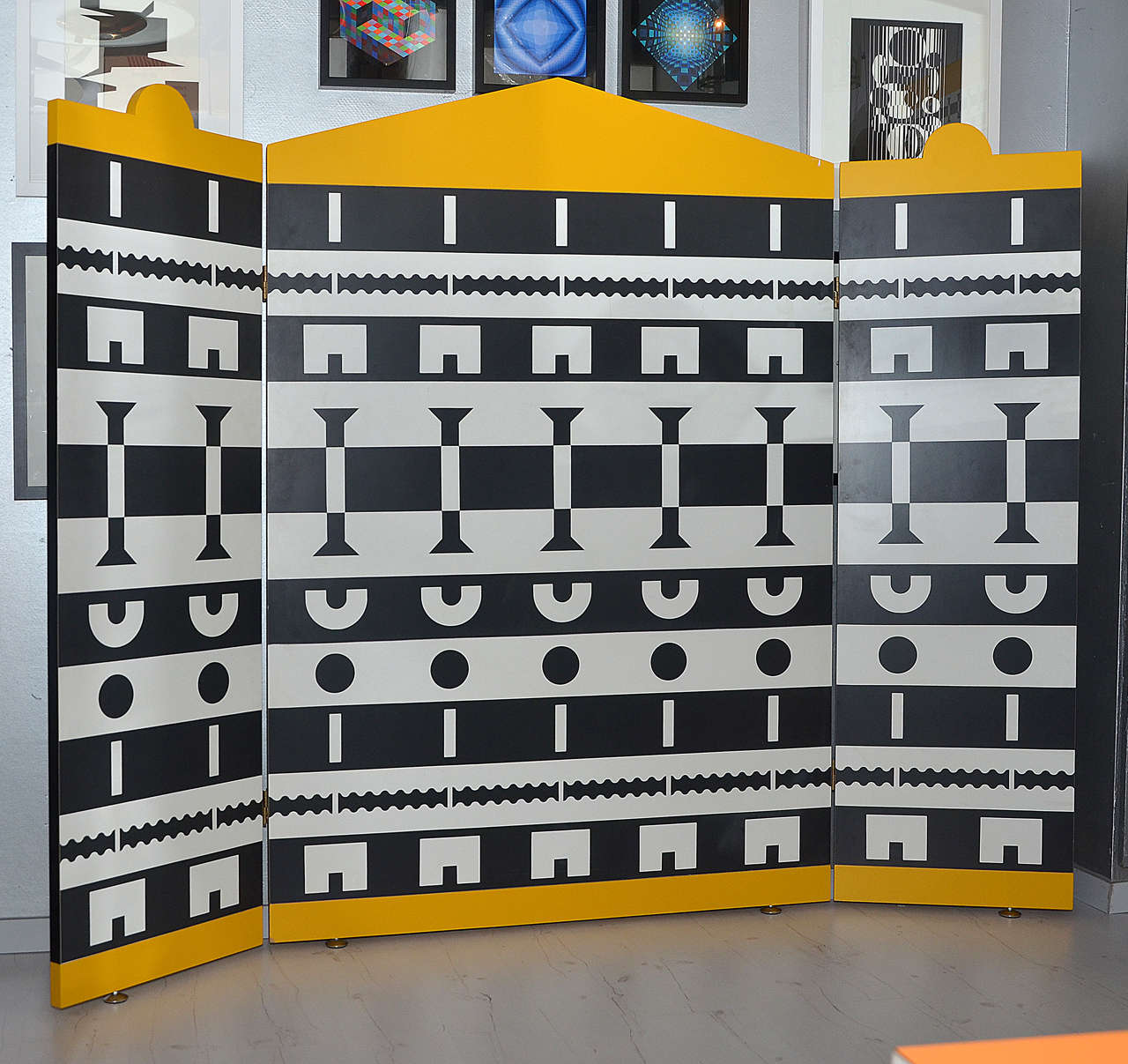 1988 three-panel screen by Alessandro Mendini and Alessandro Guerriero of the collection Ollo, edited by Alchimia; in yellow melamine decorated with black and white motifs; small legs in chromed metal. Two-sided. Dimensions of opened screen must
