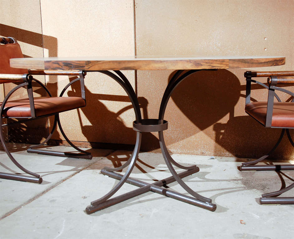 Five-piece dining set of chairs and table in iron, wood and naugahyde.