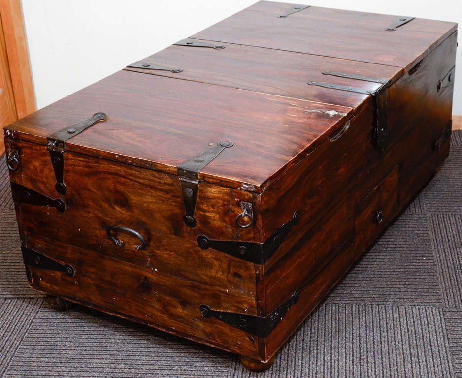 A vintage trunk in reclaimed wood with metal hinges and hardware and numerous drawers and compartments