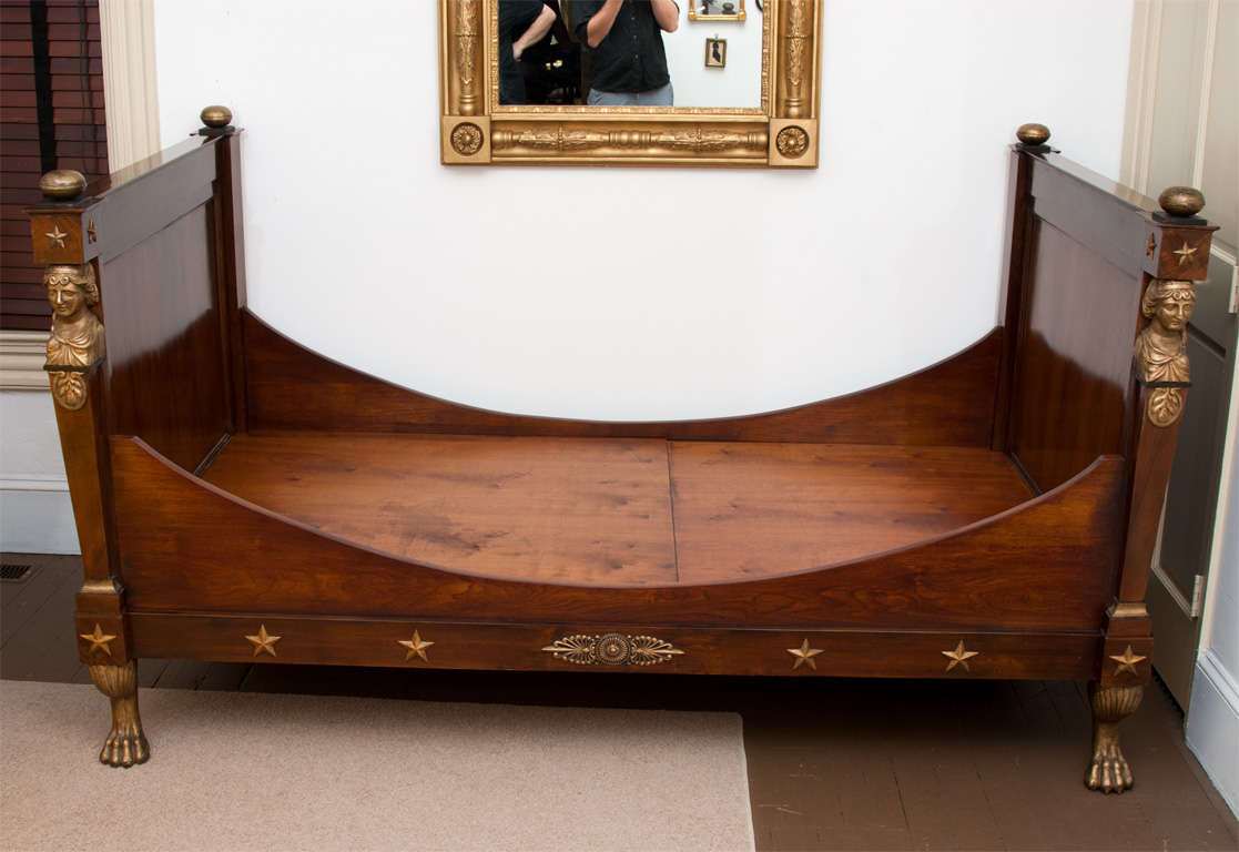 This imposing bed has hand-carved gilt caryatids for columns and animal feet in front, all original with the old gilt. Beautiful highly-figured mahogany. Unusual finials and ball back feet, also in original gilt. We have put a custom heavy duty foam
