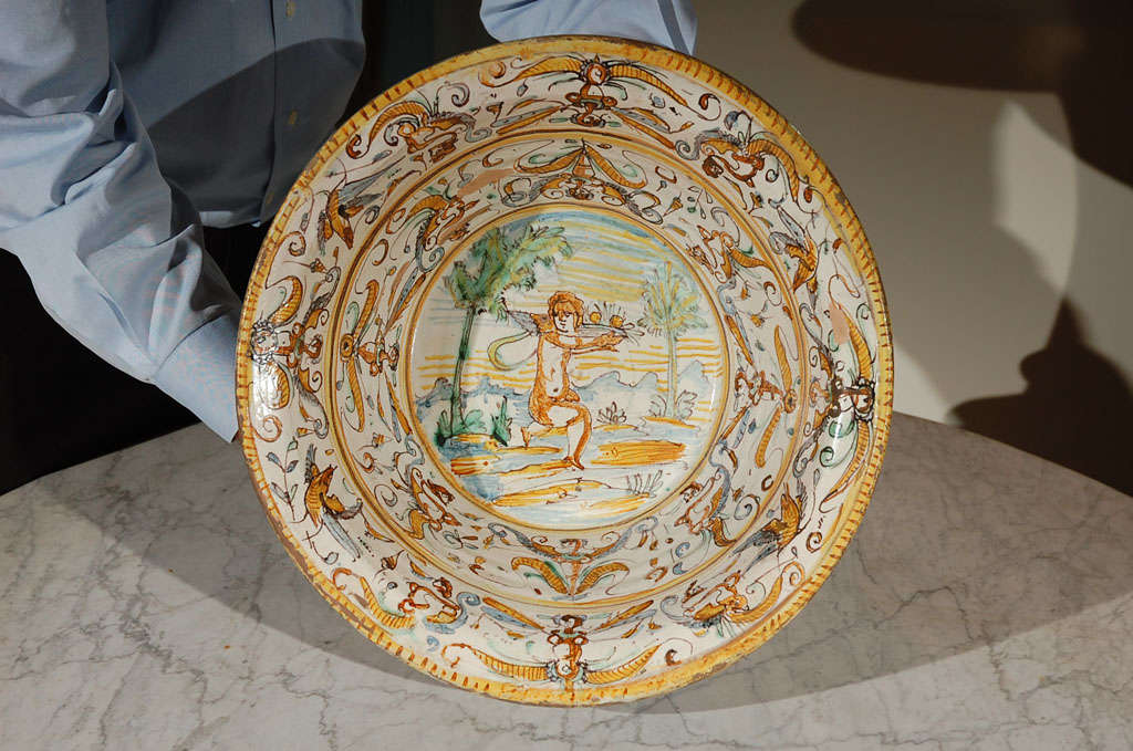 Italian Majolica Bowl with center figure in a landscape with borders of foliate scrolls, birds, and mythical beast.