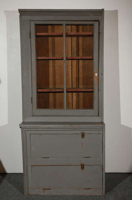 19THC ORIGINAL GREY PAINTED ONE DOOR CANDY STORE DISPLAY CABINET FROM PENNSYLVANIA.THIS STEP BACK CABINET HAS THREE SHELFS ON THE TOP AND TWO SHELFS BELOW WITH UNUSUAL PULL DOWN DOORS.THE HARDWARE IS ALL ORIGINAL AND SO ARE THE IRON HINGES.THE