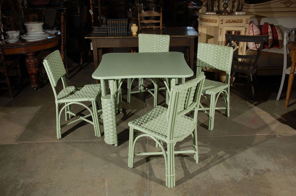 A deco style, woven wicker, table with four matching chairs. This 5 piece set is thought to be American, circa 1930's, and is painted a light green. All components are well made, solid and will prove a delight. 