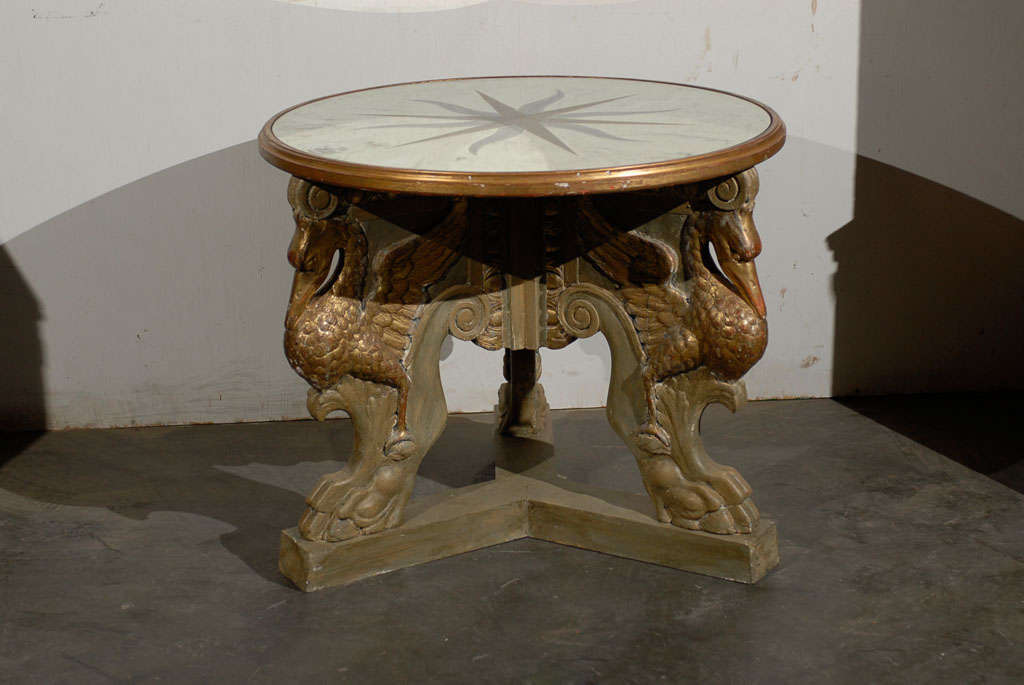 A mirrored top Italian center table with a base consisting of three storks perched on carved feet. Gorgeous star design on the mirrored top.