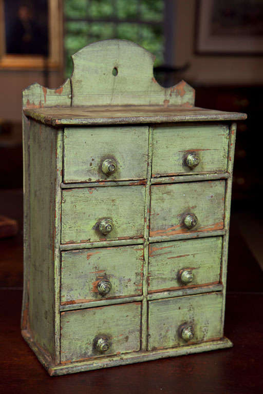 A Very Fine Green Painted Spice Chest with eight drawers and a finely scrolled backboard. In an untouched state of preservation retaining original paint, knobs and all drawers.