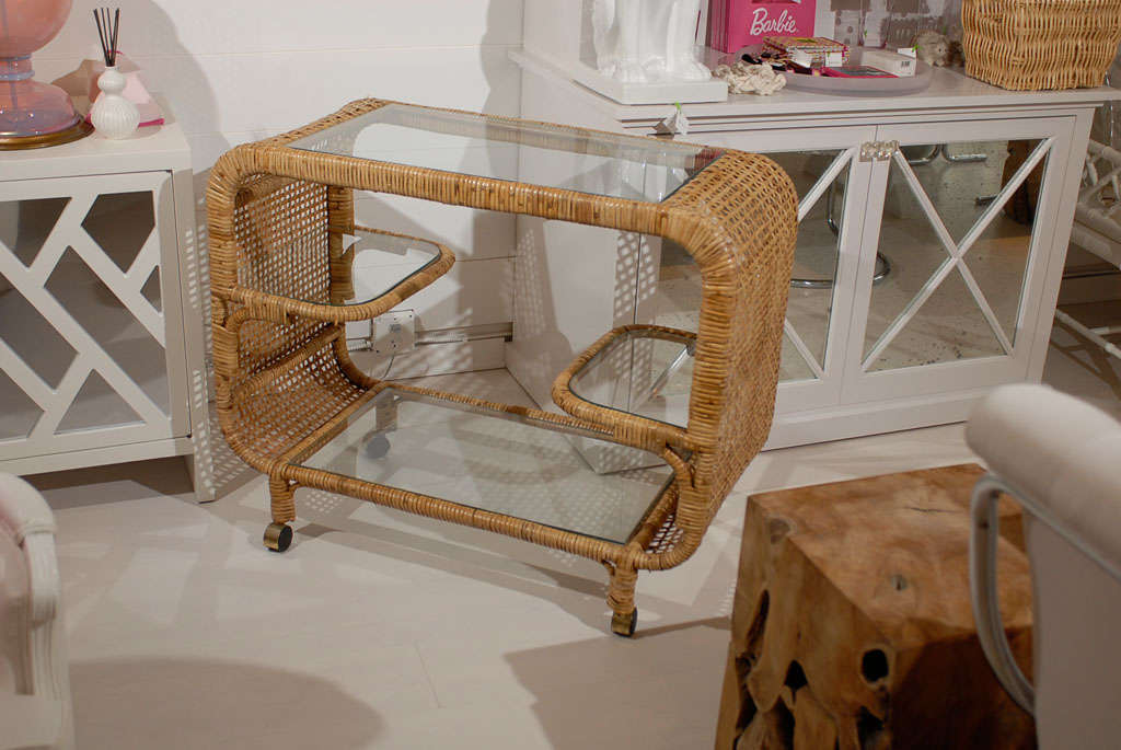 * vintage<br />
* woven rattan detail on each side of cart and along edges<br />
* glass inset on top and bottom<br />
* glass top & bottom measure 27.5W x 16D<br />
* two glass shelves on either side of bar cart<br />
* four legs wrapped in
