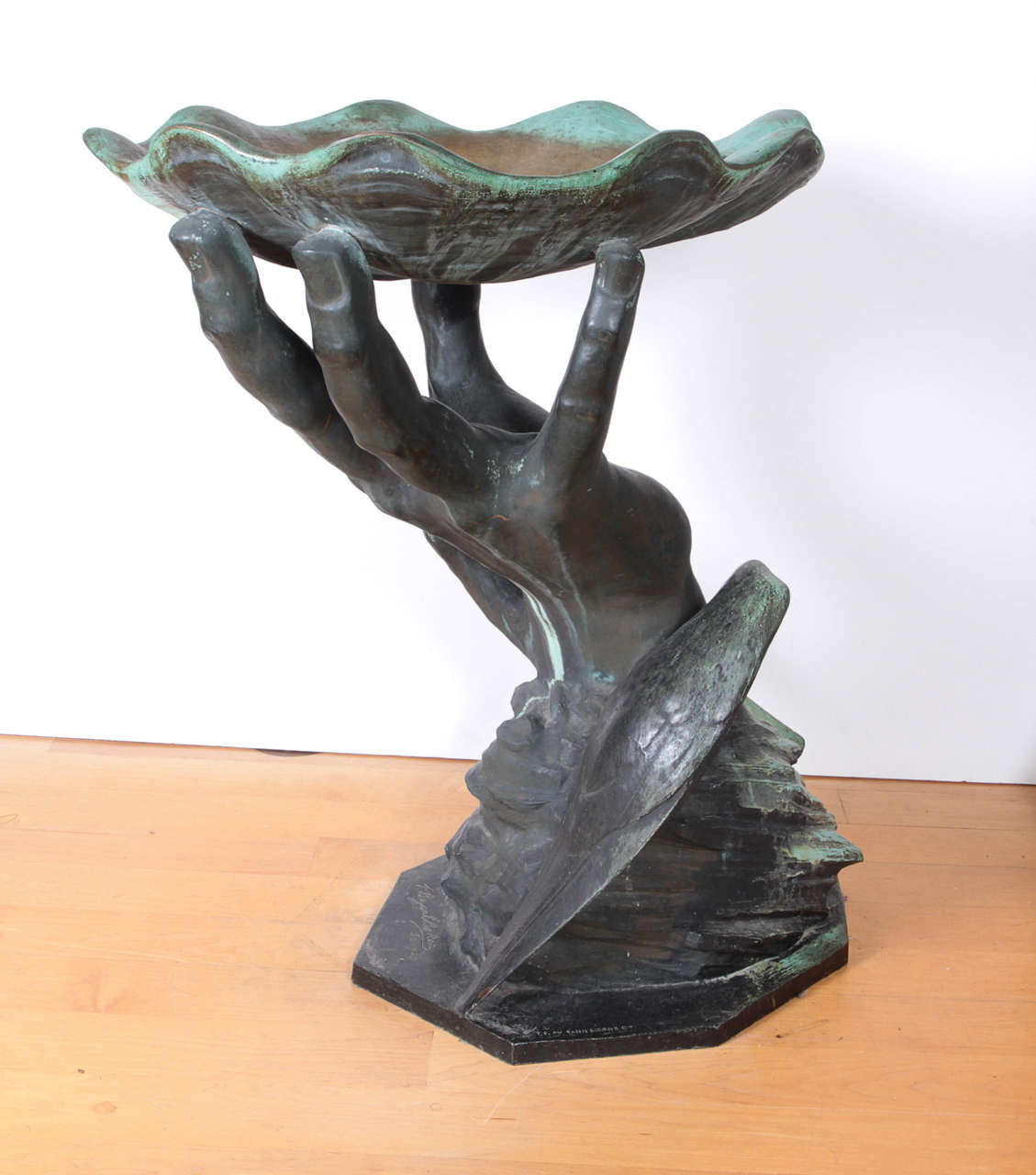 Recreation of a bronze birdbath in the form of a hand holding a scalloped shell by the artist P. Bryant Baker. Baker was known for monumental sculpture. His most famous piece is Pioneer Women--a woman 27' tall with a child--in Ponca City, Oklahoma.